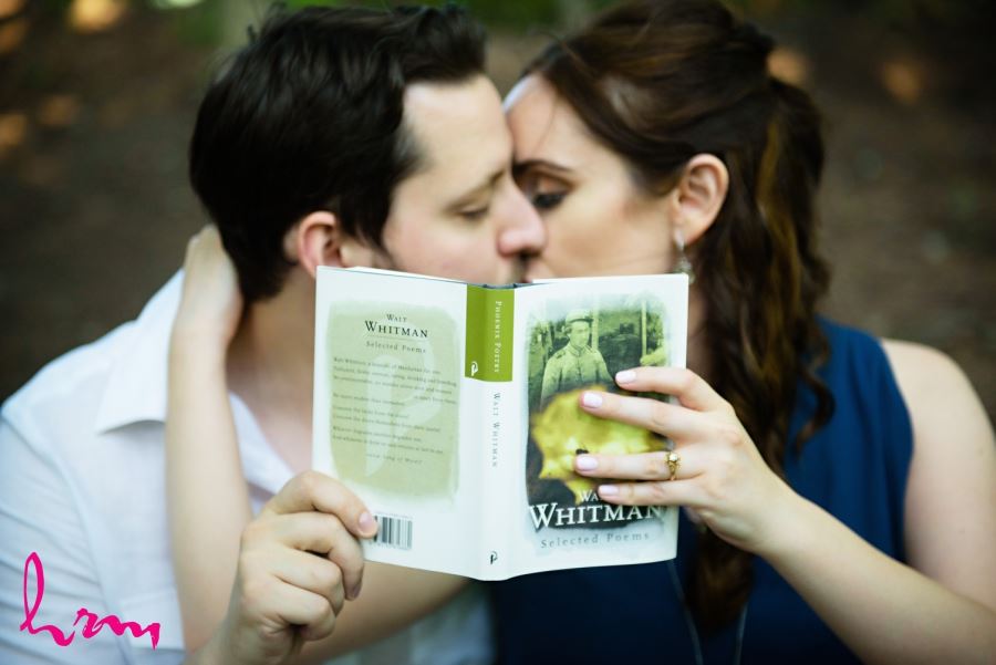 couple kissing behind book