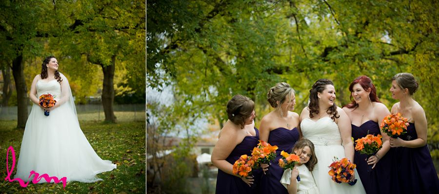 bride outside laughing with bridesmaids in front of green trees