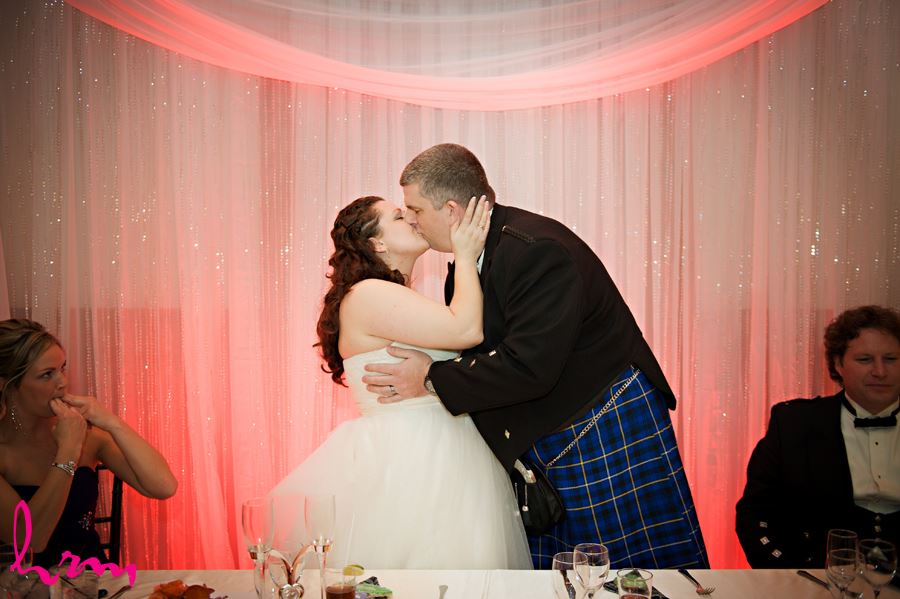 bride and groom share a kiss in the reception