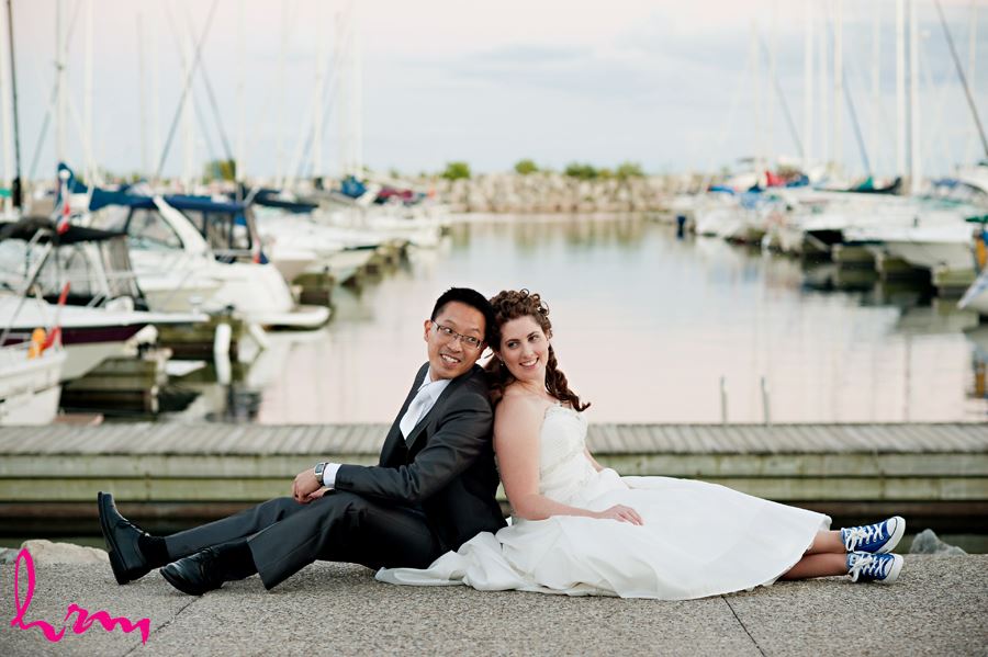 wedding couple sitting on the dock with boats in oakville ontario