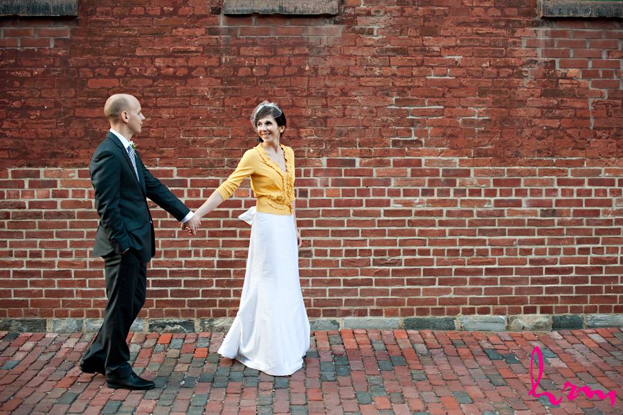 bride pulling groom walking away on brick path