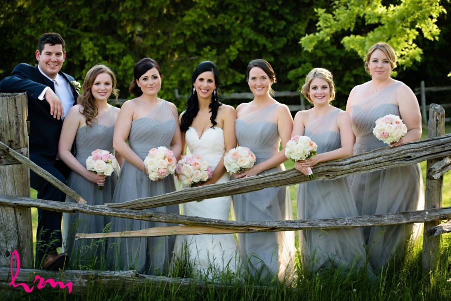 bride with bridesmaids with wooden fence