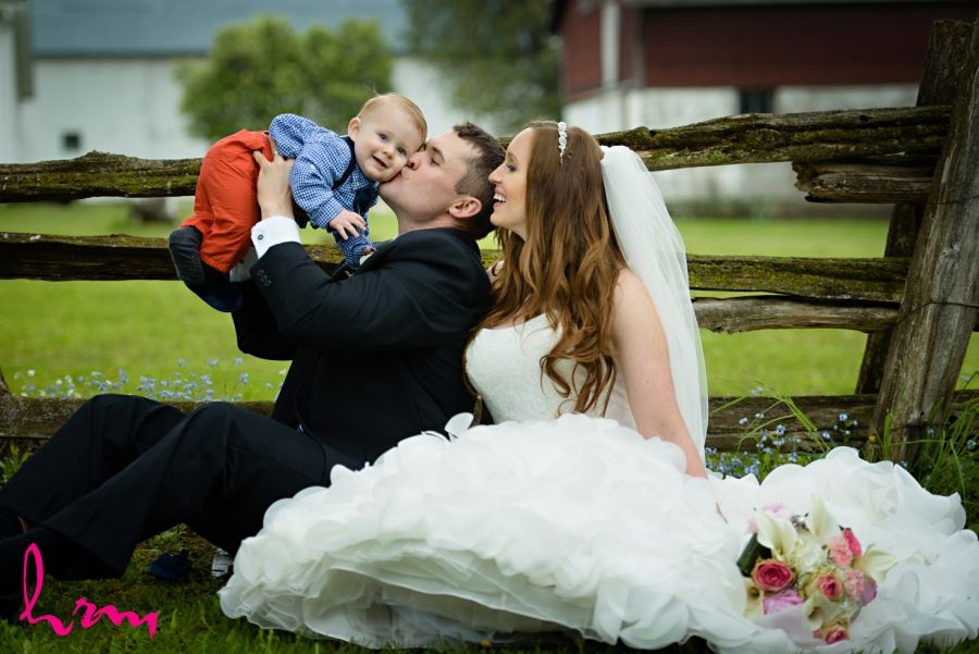 Bride and groom with baby on wedding day family