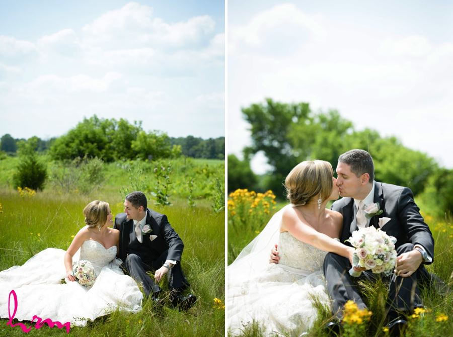 bride and groom sitting in meadow on sunny summer wedding day