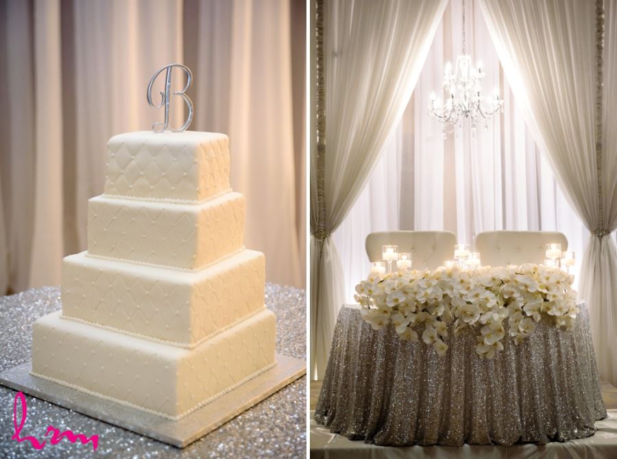 Simple white four tiered square wedding cake and orchid centrepiece head table