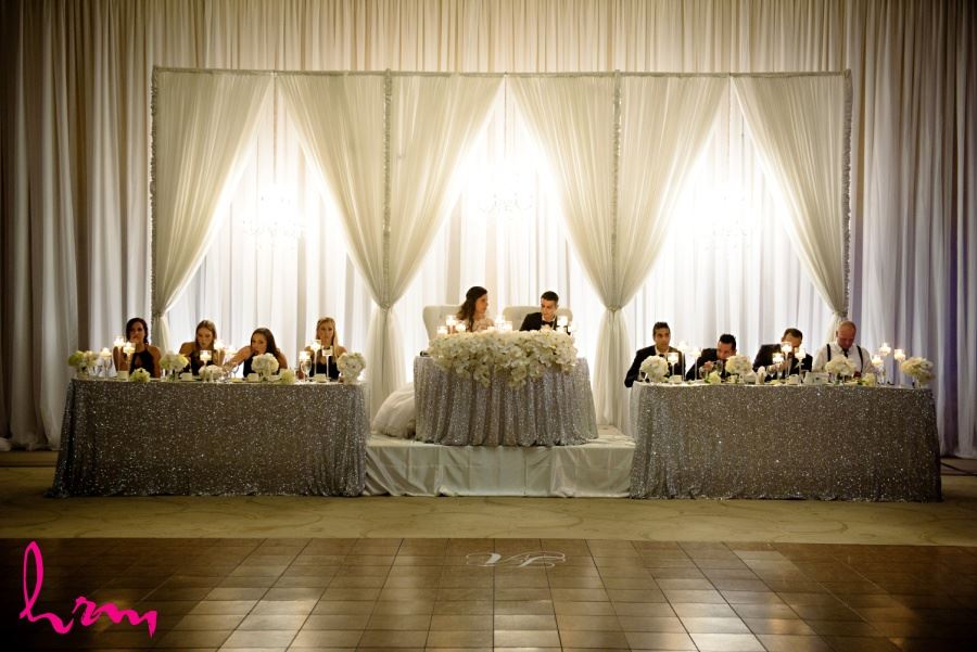 Luxurious head table with orchid cascades and sequinned table cloth