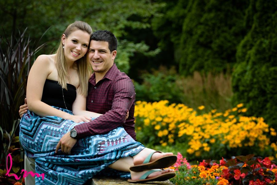 London Ontario engagement session couple sitting in front of bright flowers