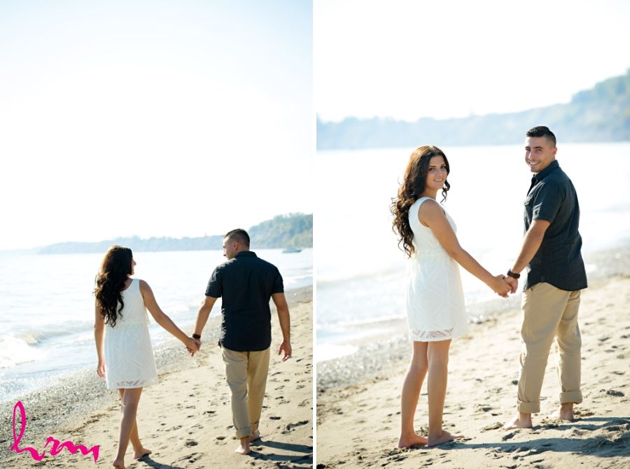 sunny beach engagement session couple walking on sand