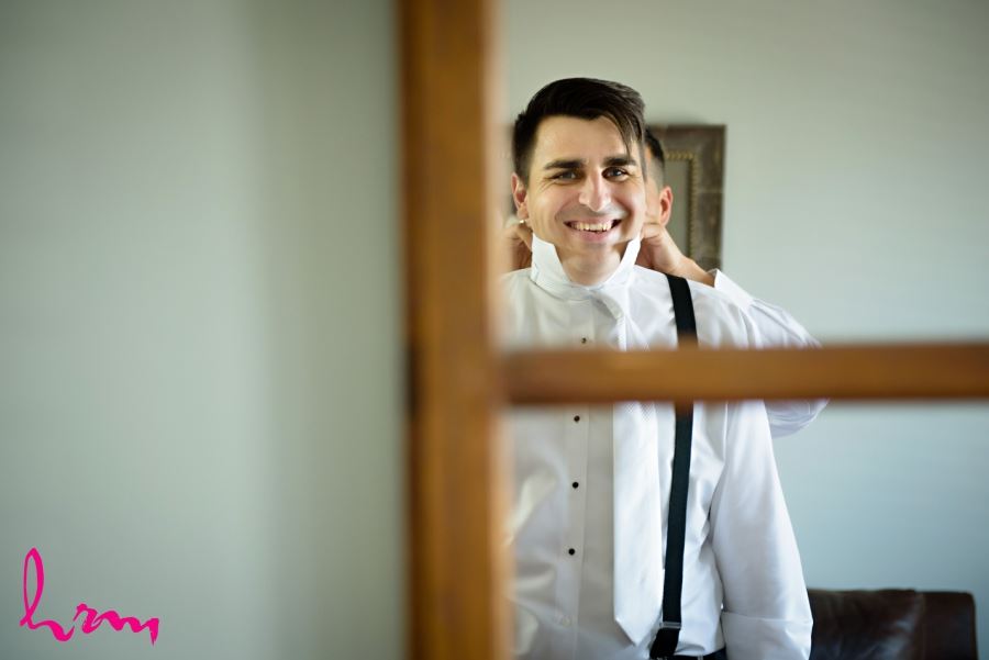 groom getting ready in mirror