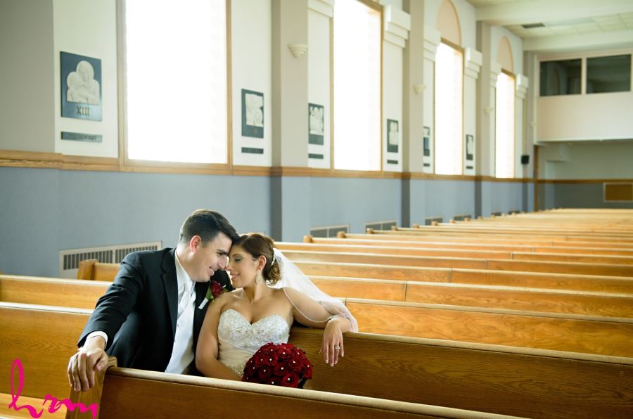 bride and groom sitting in pews of church