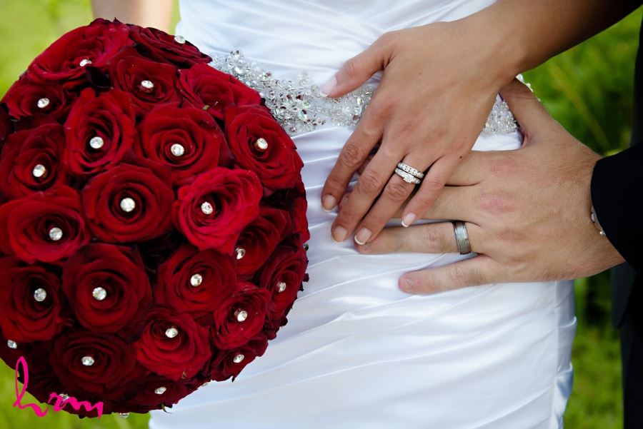 bride and grooms hands with rings and bouquet 