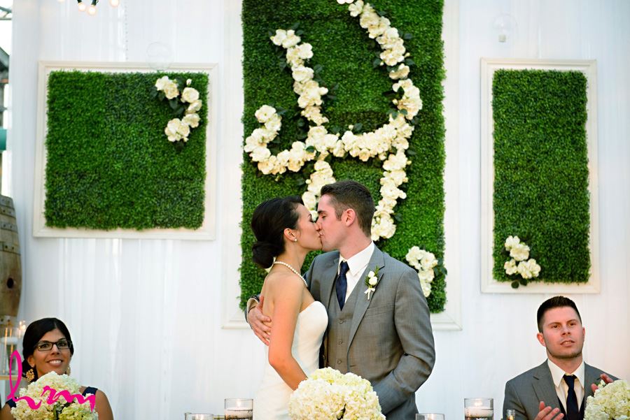 Geneviève + Will kiss during dinner Heeman Greenhouses London ON Wedding Photography