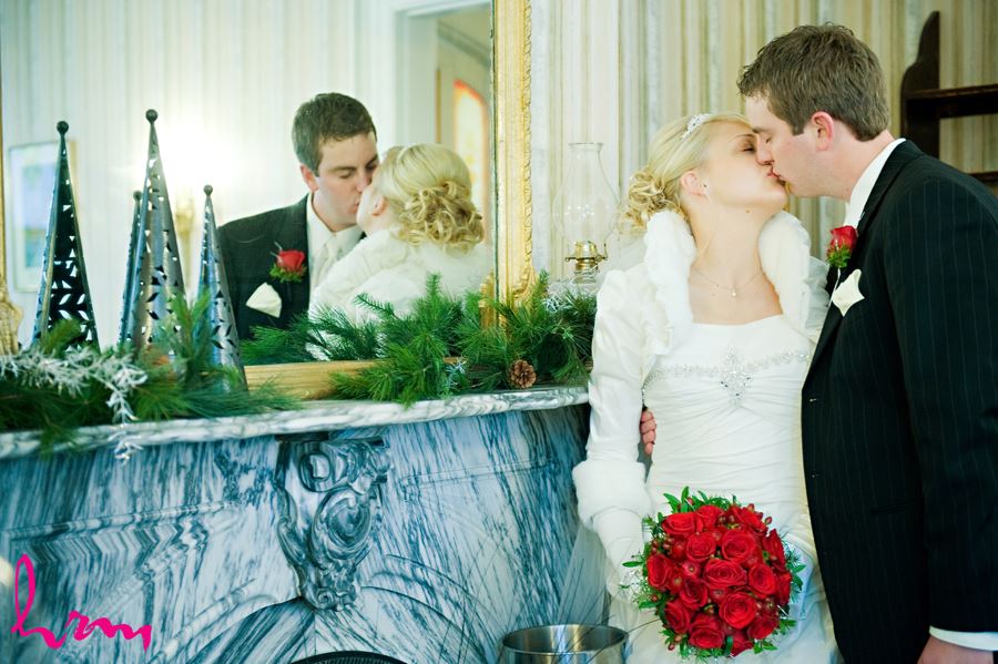 bride and groom kissing by a mirror