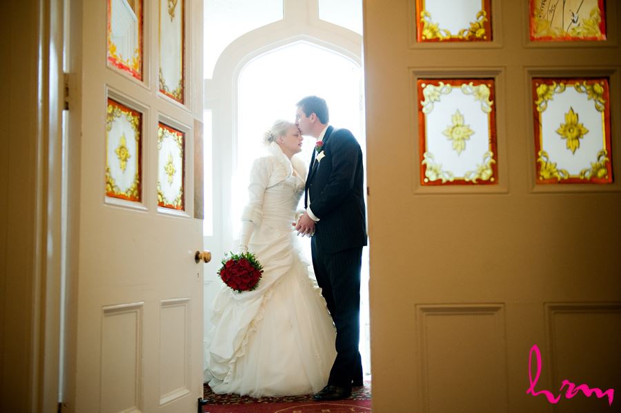 bride and groom sharing a kiss by a doorway at the elmhurst inn in ingersoll