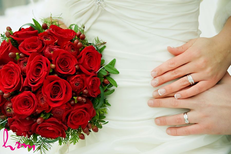 wedding rings close up with red roses