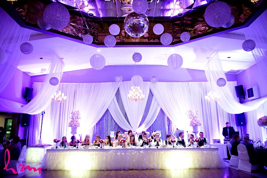 head table with draping and sequinned backdrop and chandeliers