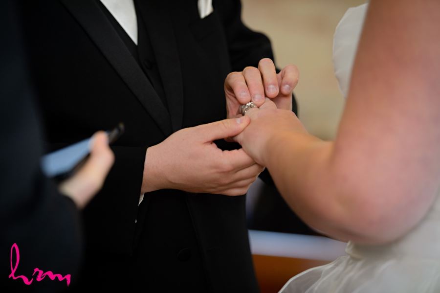 groom putting ring on bride
