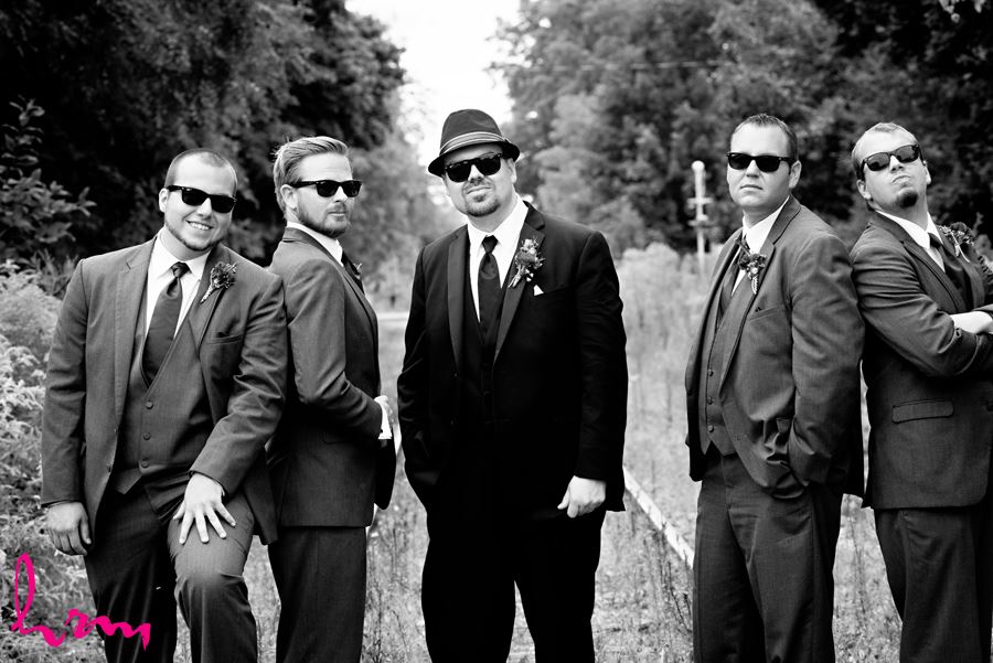 Black and white photo of Will and groomsment outside CASO Railway Station St. Thomas ON Wedding Photography