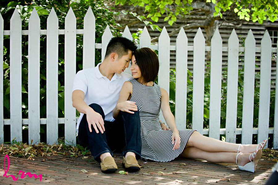 Couple sitting by picket fence