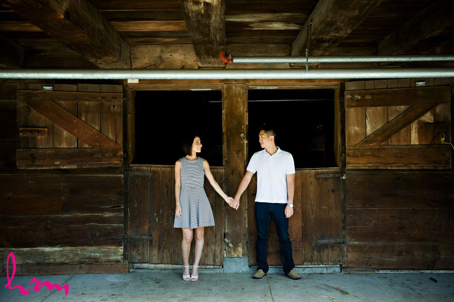 Engaged couple infront of wooden barn doors at Riverdale Farm