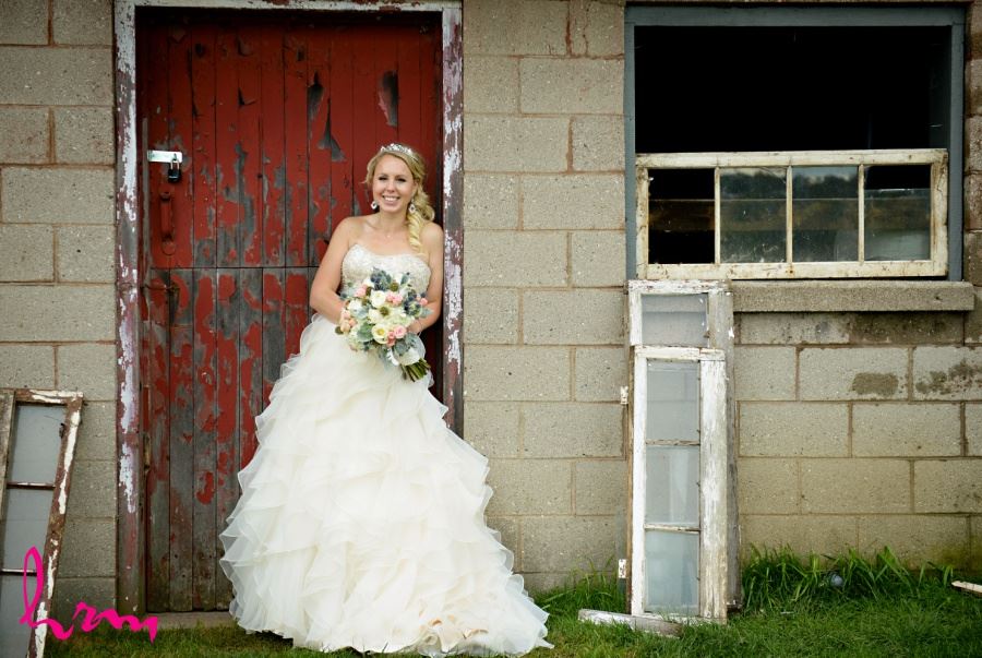 Bride in front of old red barn door