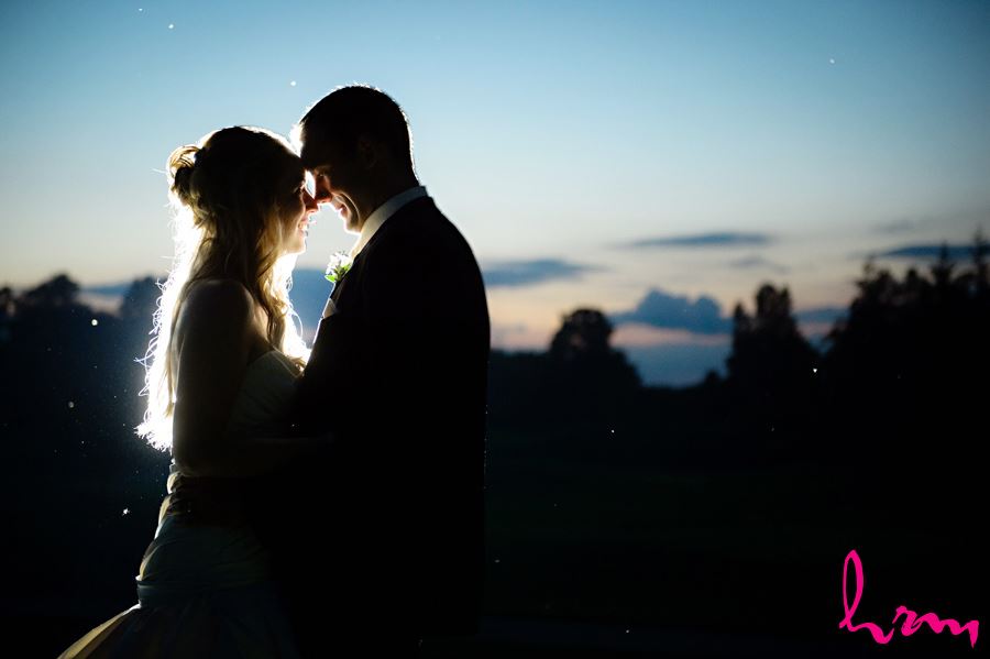 bride and groom cuddle forehead to forehead at night in London Ontario